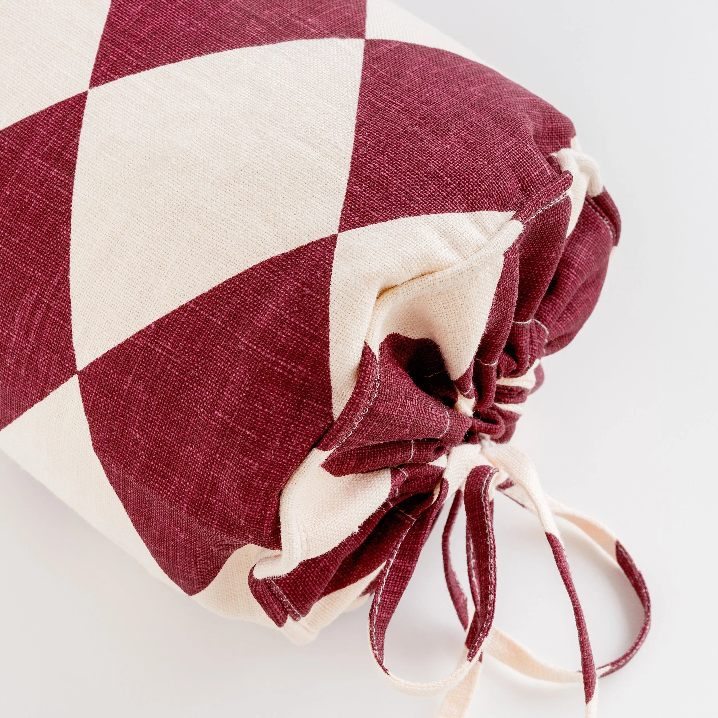 Harlequin linen bolster, claret/cream